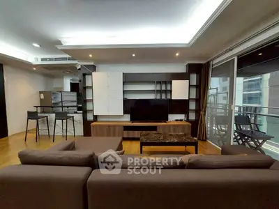 Spacious modern living room with sleek furniture and large windows offering city views.