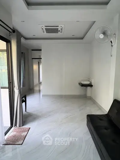 Spacious modern living room with sleek flooring and large windows for natural light.