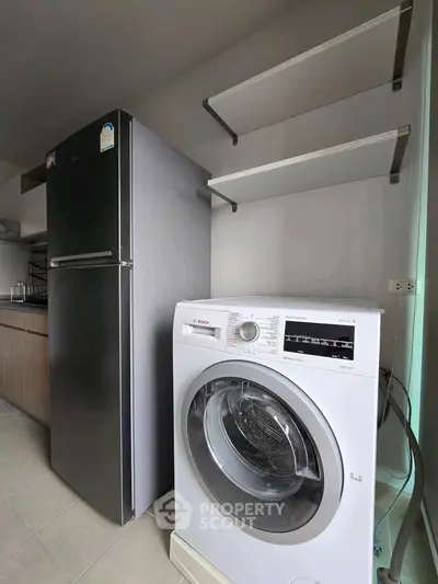 Modern kitchen with sleek fridge and washing machine, perfect for urban living.