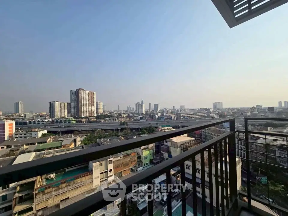 Stunning cityscape view from a high-rise balcony, showcasing urban skyline and clear skies.