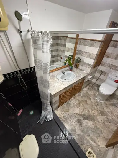 Modern bathroom with stylish tiles and sleek fixtures, featuring a shower and vanity area.