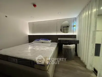 Modern bedroom with stylish decor and ambient lighting, featuring a large bed and elegant furnishings.