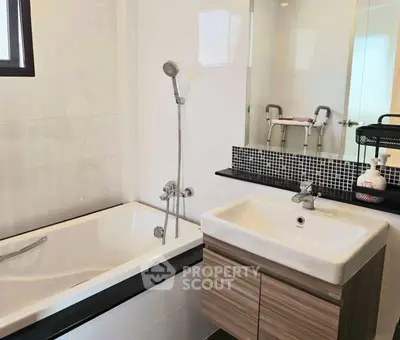 Modern bathroom with sleek bathtub and stylish sink in contemporary home.