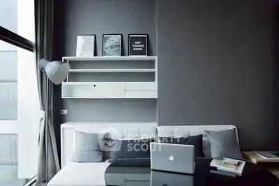 Modern living room with sleek decor and natural light, featuring a stylish sofa and wall art.