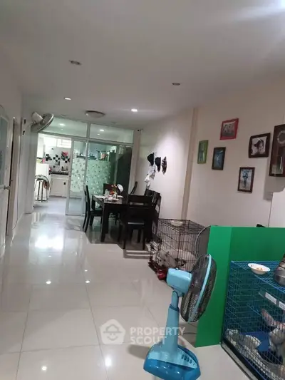Spacious dining area with tiled flooring and modern decor, leading to a well-equipped kitchen.