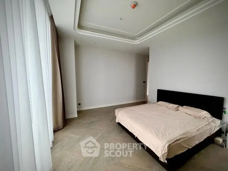Spacious bedroom with elegant design and large windows for natural light.