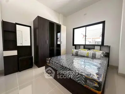 Modern bedroom with sleek furniture and large window for natural light.