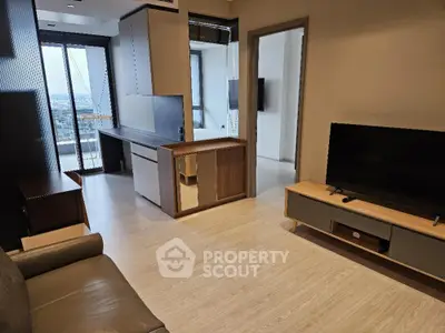 Spacious living room with modern open layout kitchen, ample natural light, and sleek wooden flooring, perfect for urban living.