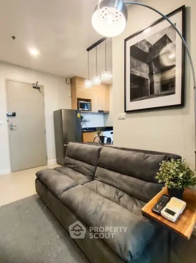 Modern living room with cozy sofa and stylish kitchen in open layout apartment.