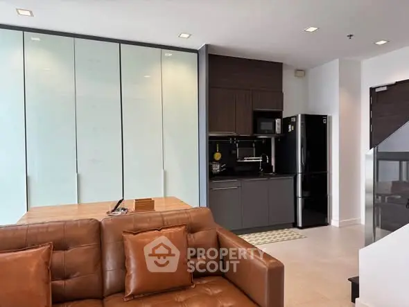 Modern open-layout kitchen with sleek appliances and cozy seating area