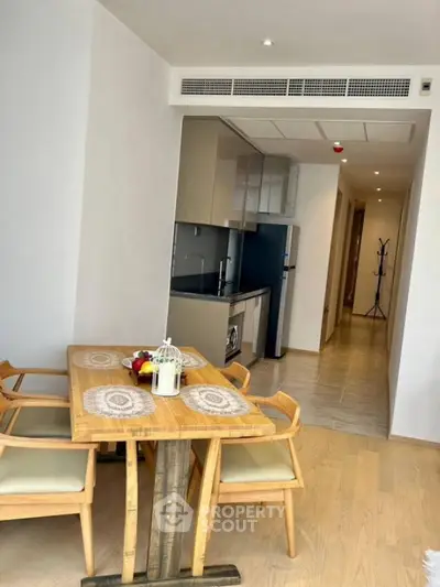 Modern dining area with wooden furniture and open kitchen layout