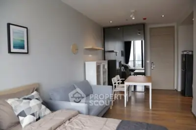 Modern studio apartment with stylish decor and open layout, featuring a cozy living area and dining space.