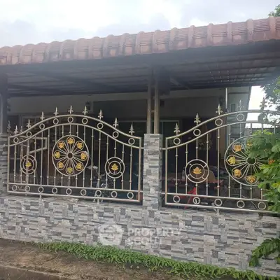 Charming home exterior with decorative wrought iron fence and tiled roof, perfect for cozy living.