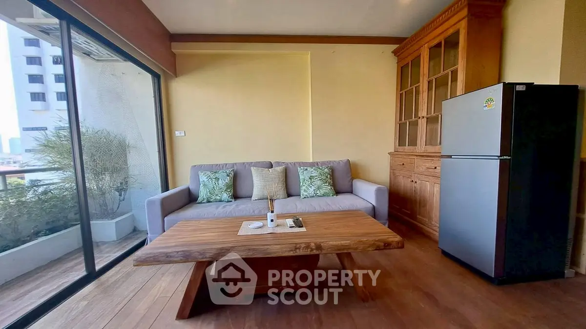 Charming living room with cozy sofa, wooden table, and modern fridge, perfect for relaxation and entertaining.
