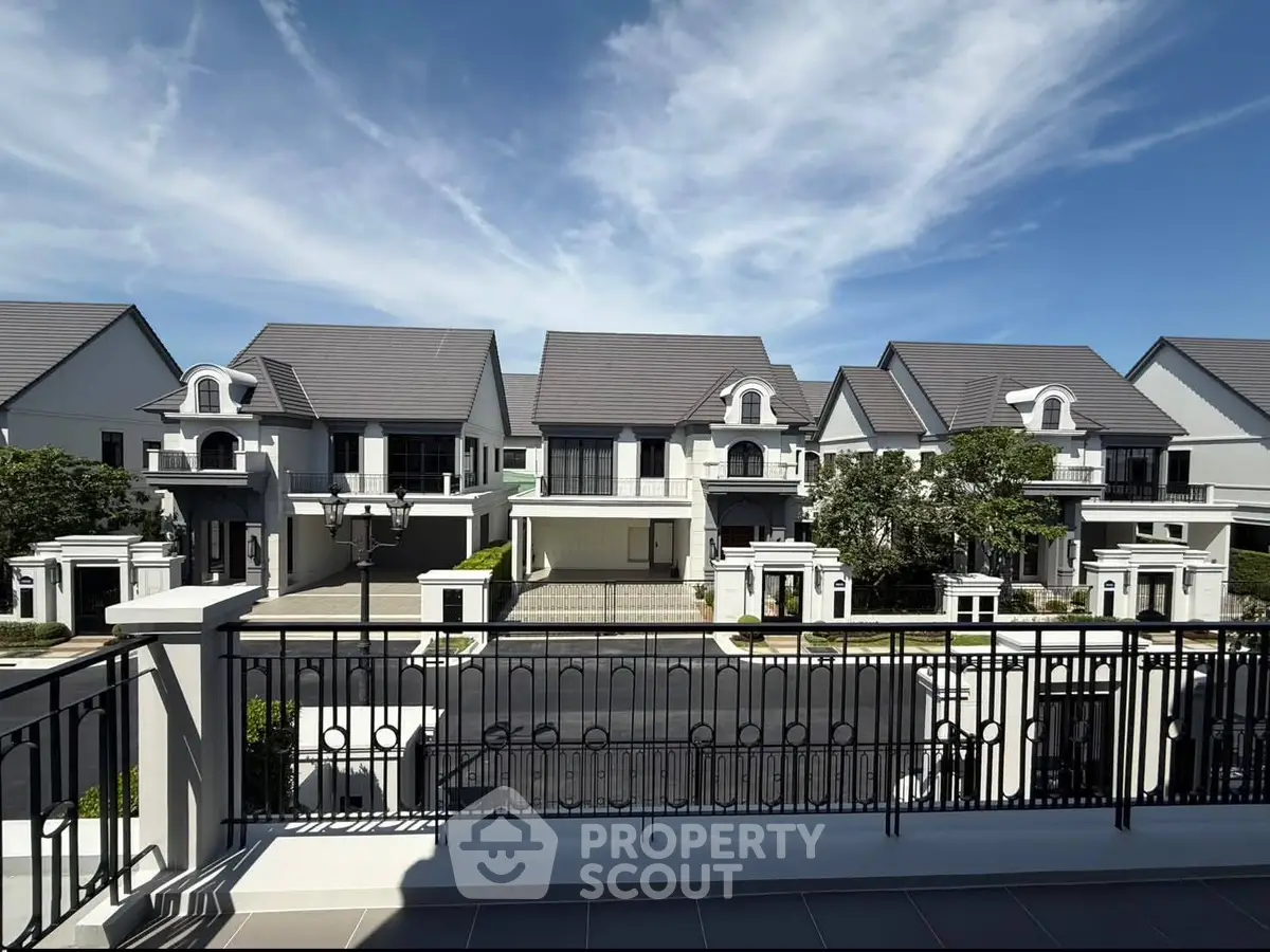 Luxurious suburban homes with elegant architecture and spacious driveways under a clear blue sky.