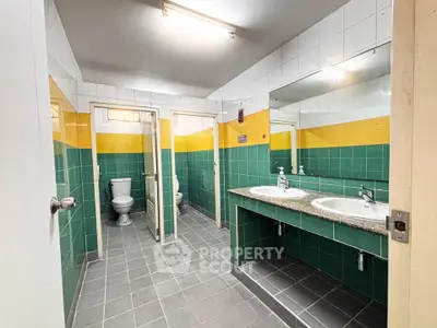 Spacious public restroom with dual sinks and vibrant tile design.