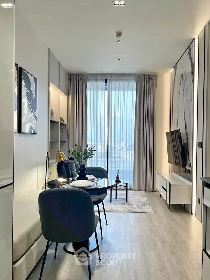 Modern living room with elegant decor and large window offering stunning city view.