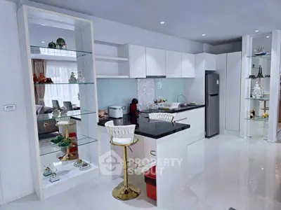 Modern open-layout kitchen with sleek white cabinets and stylish bar seating