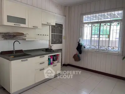 Charming kitchen with closed layout and gas stove, featuring ample storage and natural light.
