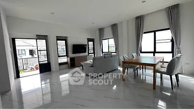 Spacious modern living room with large windows and elegant dining area