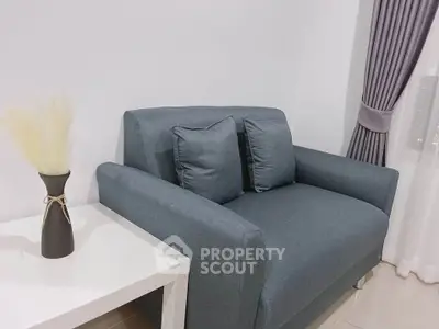 Cozy living room corner with modern gray sofa and elegant white side table.