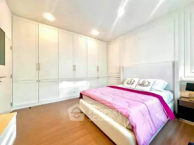 Spacious bedroom with elegant built-in wardrobes and cozy bed in modern apartment.
