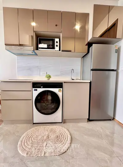 Modern kitchen with sleek cabinets, built-in microwave, and washer-dryer combo in a compact layout.