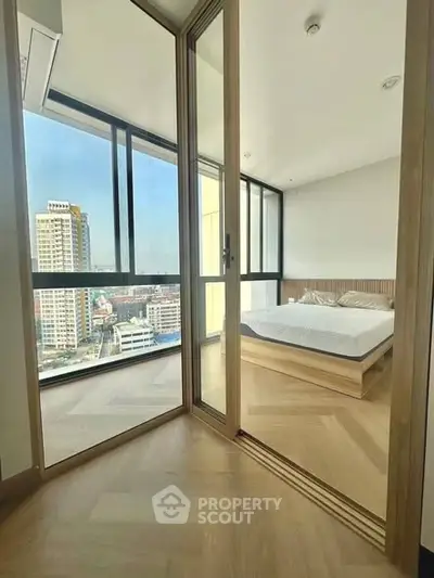 Modern bedroom with floor-to-ceiling windows and city view, featuring minimalist design and wooden flooring.