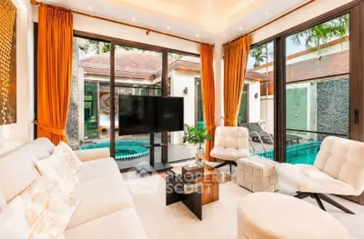 Luxurious living room with pool view, elegant decor, and ample natural light in a modern home.
