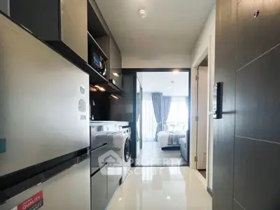 Modern apartment interior with sleek kitchen and view into a cozy bedroom