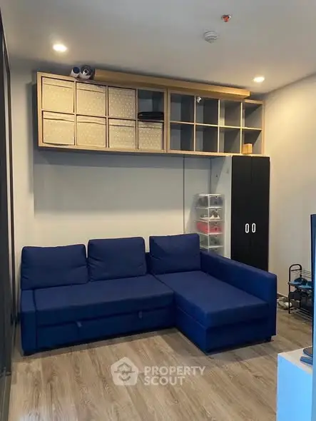 Modern living room with blue sectional sofa and stylish storage solutions.