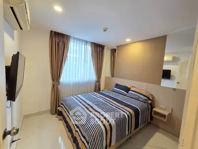 Cozy bedroom with modern decor, featuring a comfortable bed, wall-mounted TV, and elegant curtains.