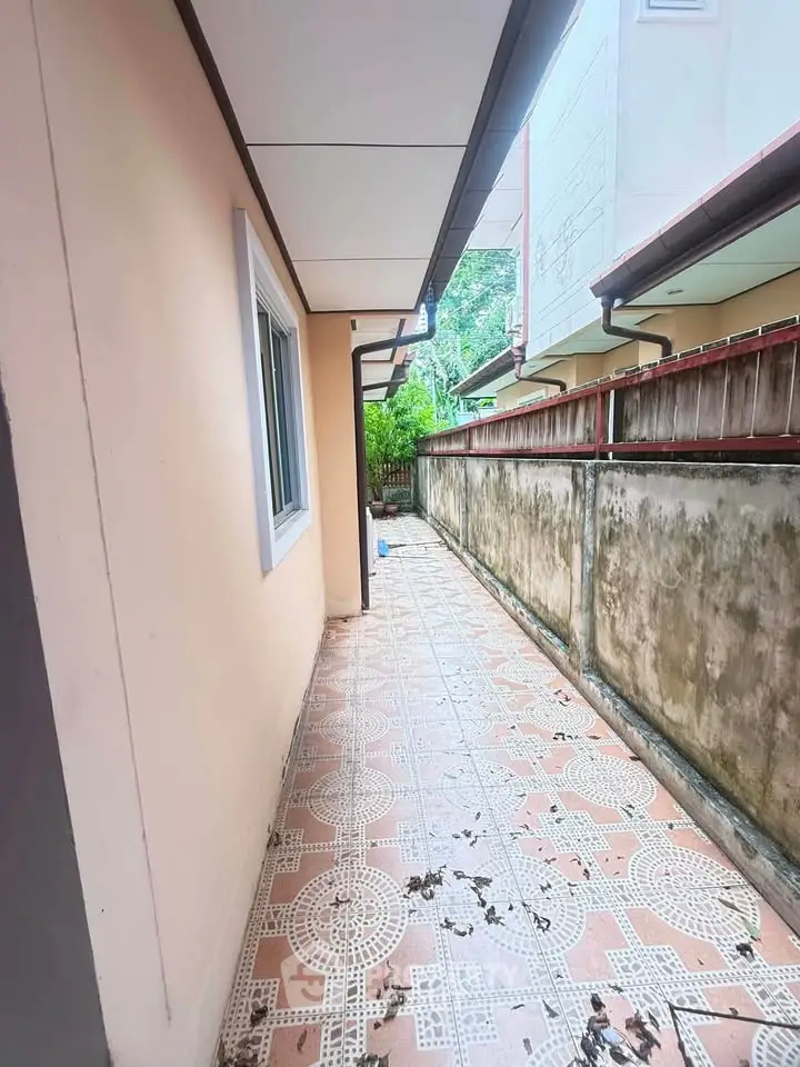 Charming side pathway with tiled flooring and garden view in a cozy residential property.