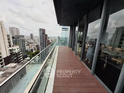 Stunning high-rise balcony with panoramic city views and modern glass railing.