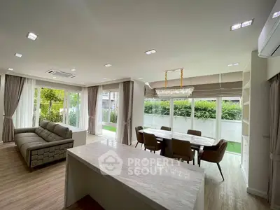 Spacious modern living room with open layout and garden view, featuring elegant dining area and luxurious finishes.