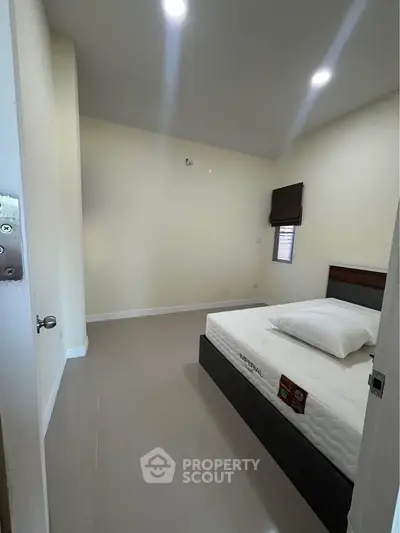 Spacious bedroom with modern design and comfortable bed in a well-lit apartment.