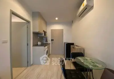 Modern compact apartment with open kitchen and dining area, featuring sleek appliances and stylish decor.