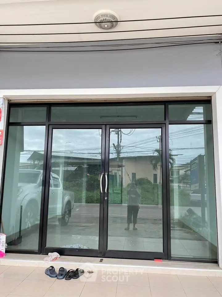 Modern glass storefront with sliding doors and tiled entrance, ideal for retail or office space.