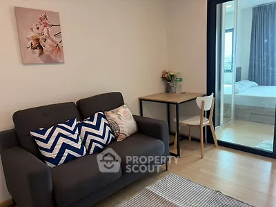Cozy living room with modern decor and view into a bright bedroom