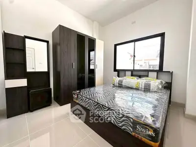 Modern bedroom with sleek furniture and large window, perfect for natural light lovers.