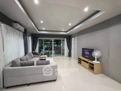 Spacious modern living room with sleek design and large windows offering natural light.