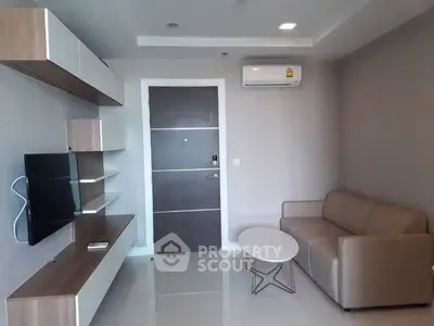 Modern living room with sleek furniture and wall-mounted TV in a stylish apartment.