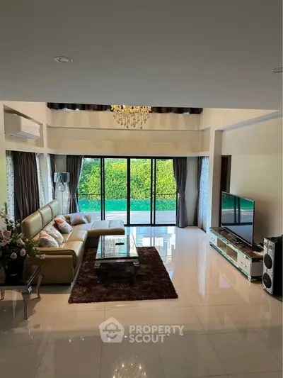 Luxurious living room with elegant decor and pool view, featuring a spacious layout and modern amenities.