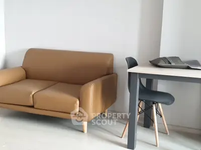 Modern living room with stylish brown sofa and sleek dining table
