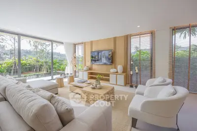 Luxurious living room with modern decor and large windows overlooking a lush garden, perfect for relaxation.