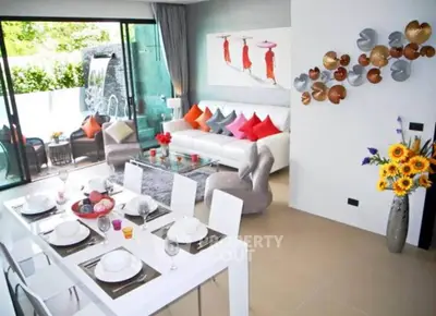 Modern living room with vibrant decor and dining area, featuring large windows and stylish furniture.