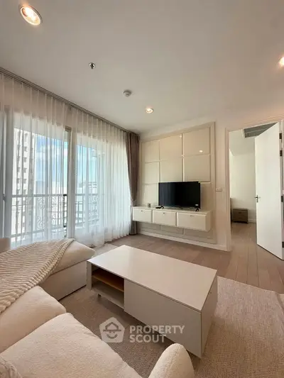 Bright and modern living room with large windows and stylish furniture.