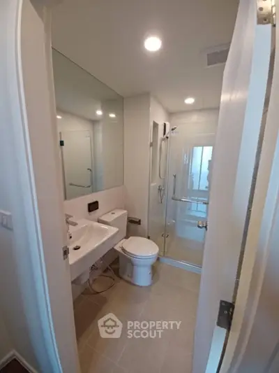 Modern bathroom with glass shower and sleek fixtures in a contemporary apartment.
