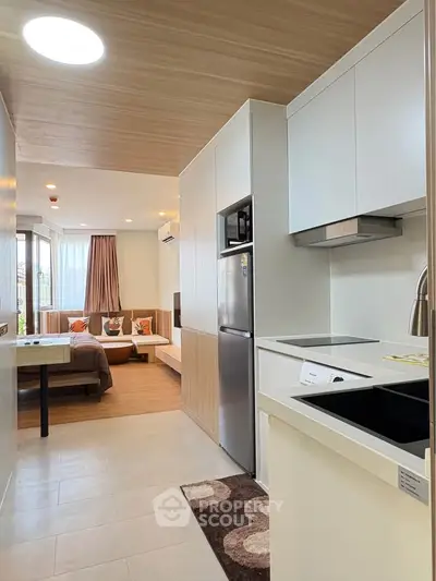 Modern open-layout kitchen and living area with sleek design and natural light.