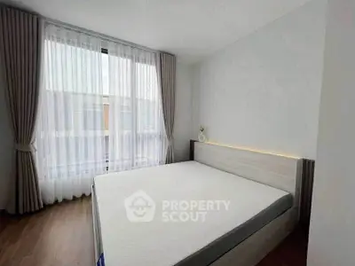 Bright minimalist bedroom with large window and modern bed design.